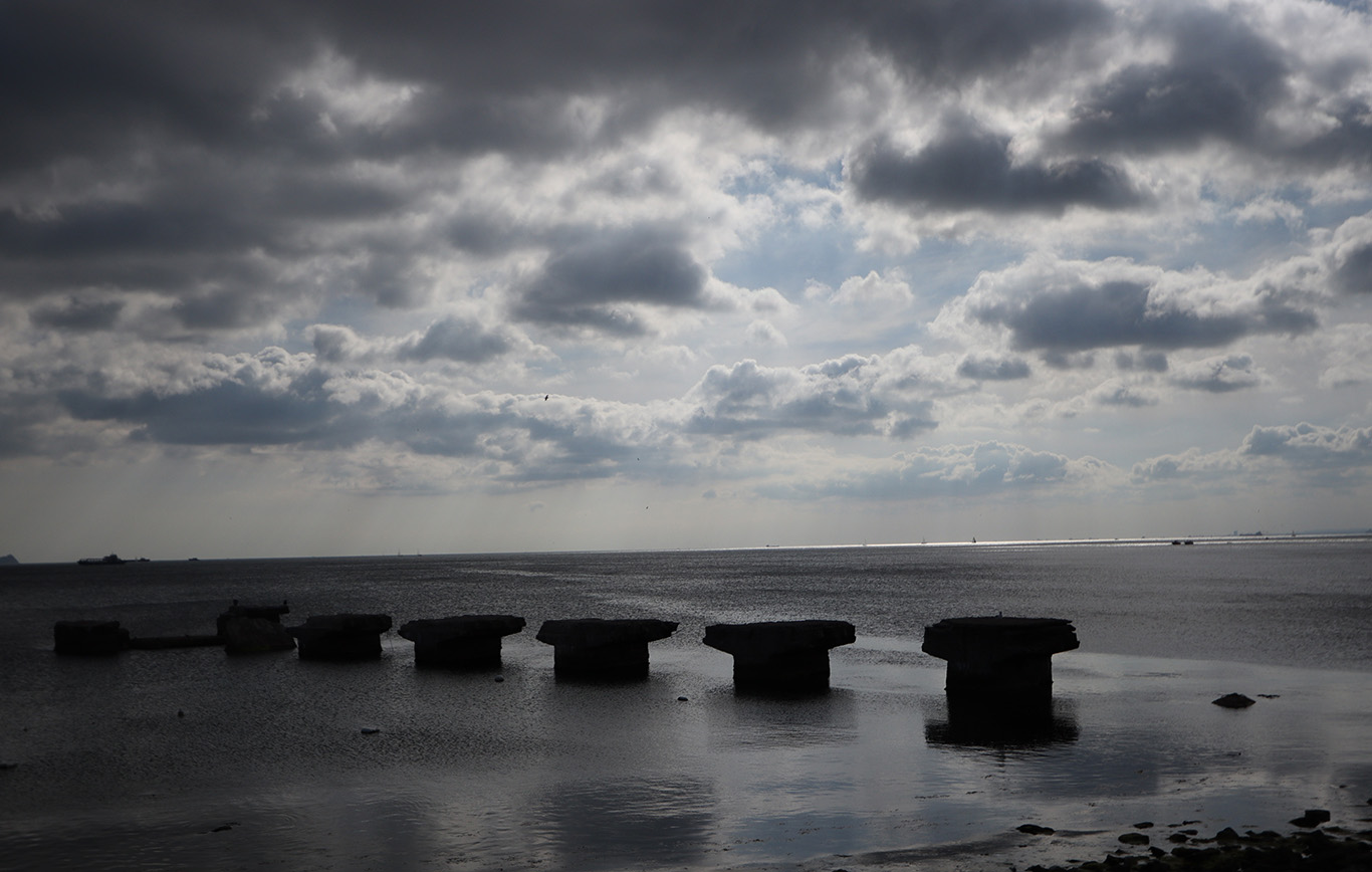 The piers of a broken bridge in the middle of the sea.