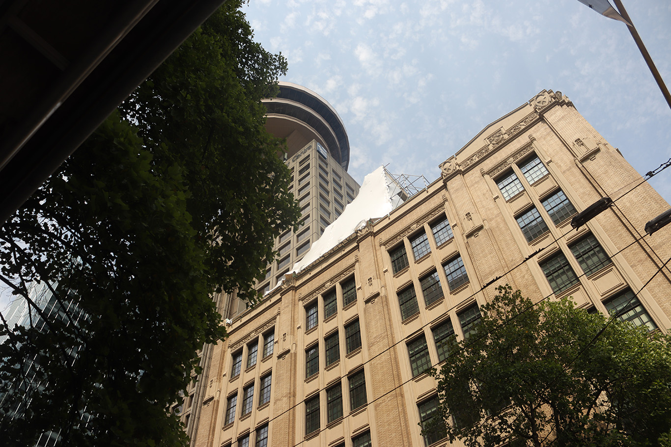 A silhouette of a tall tower blocked by a building under construction.