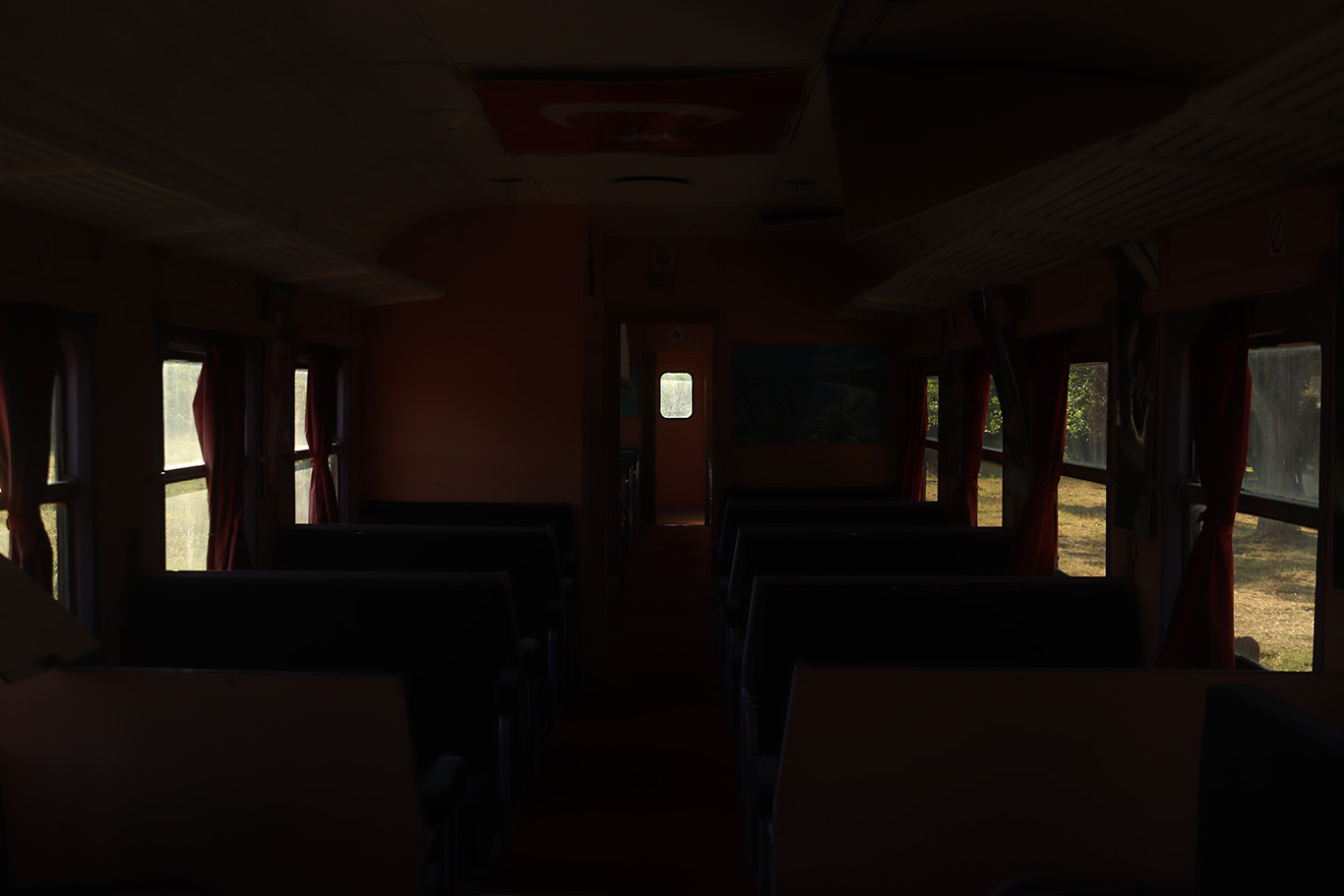 Inside of a dark passenger railroad car.
